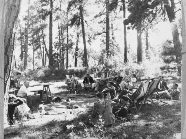 Conference participants sitting under the trees