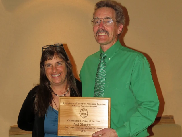 Sheppard holding the award plaque