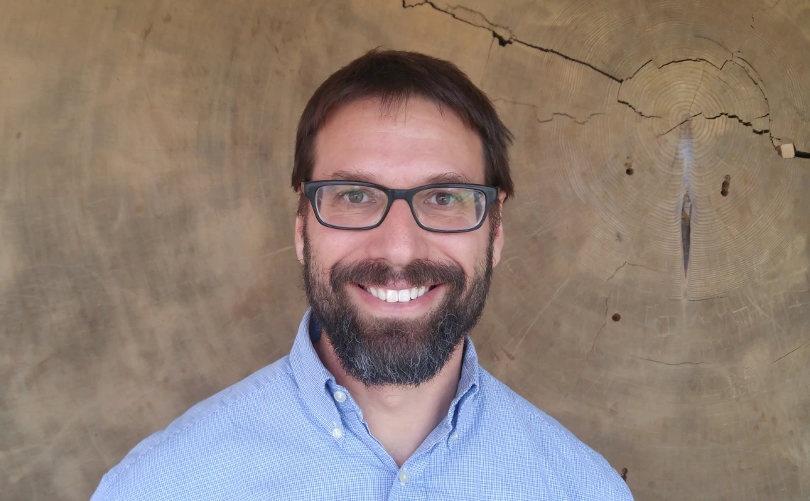 David Frank in front of the giant sequoia cross section in the Bannister Building lobby
