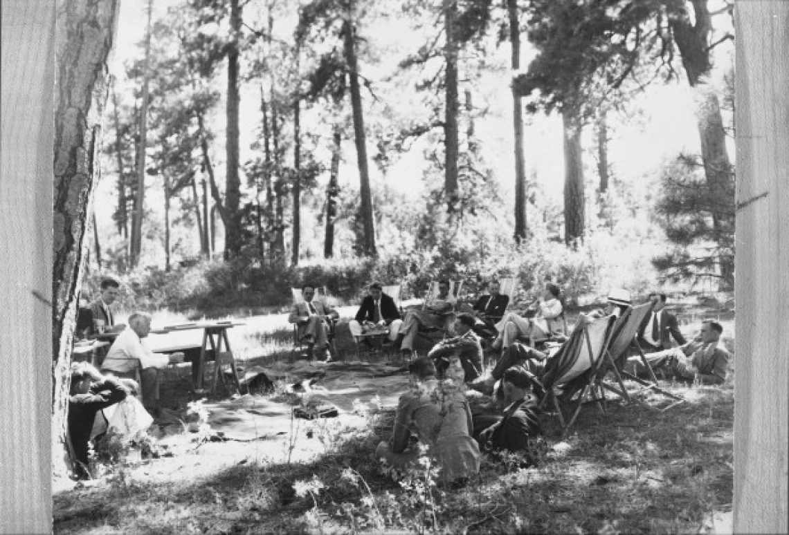 Conference participants sitting under the trees