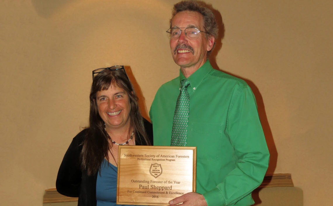 Sheppard holding the award plaque