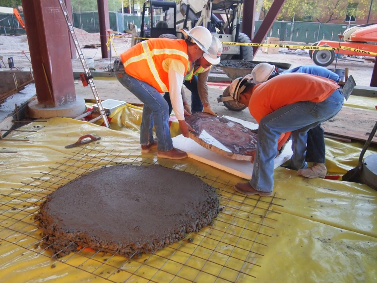 Moving a polished section of petrified wood onto a concrete pad